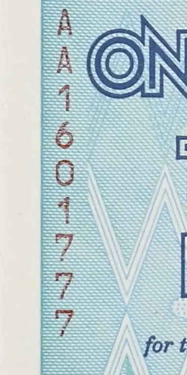 Red serial number AA1601777 printed top to bottom at the left edge of a genuine Zimbabwe 100 trillion dollar note